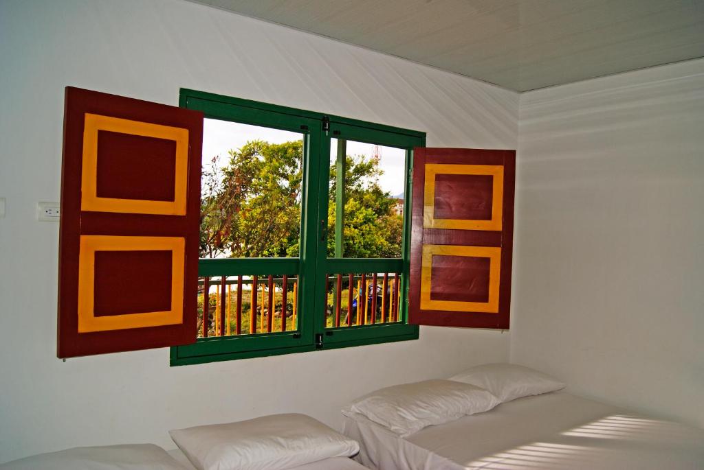 a room with two beds and a window at Hostal Casa de Los Taitas in Salento