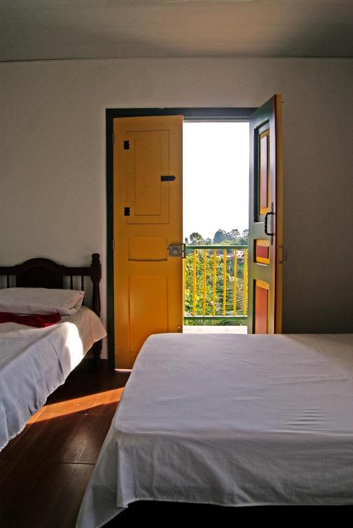a bedroom with two beds and an open door at Hostal Casa de Los Taitas in Salento
