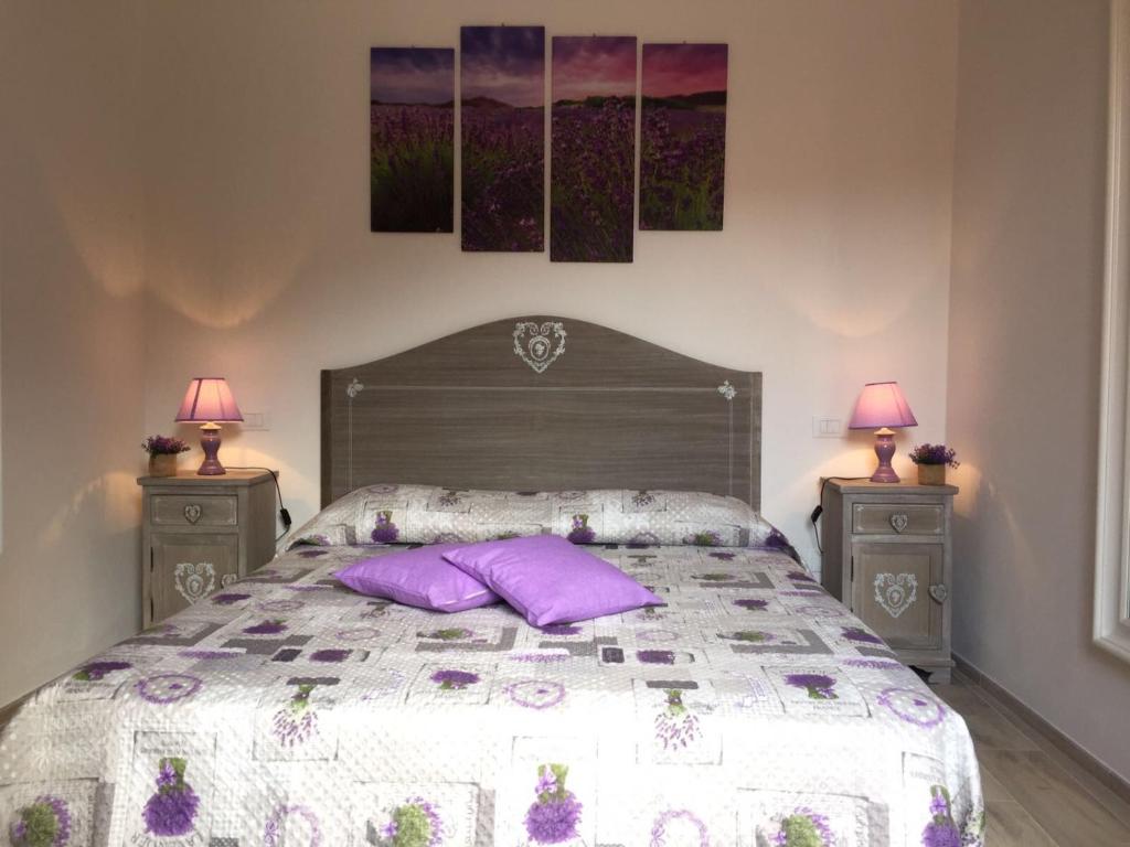 a bedroom with a bed with purple pillows on it at Casetta Lavanda in Pomonte