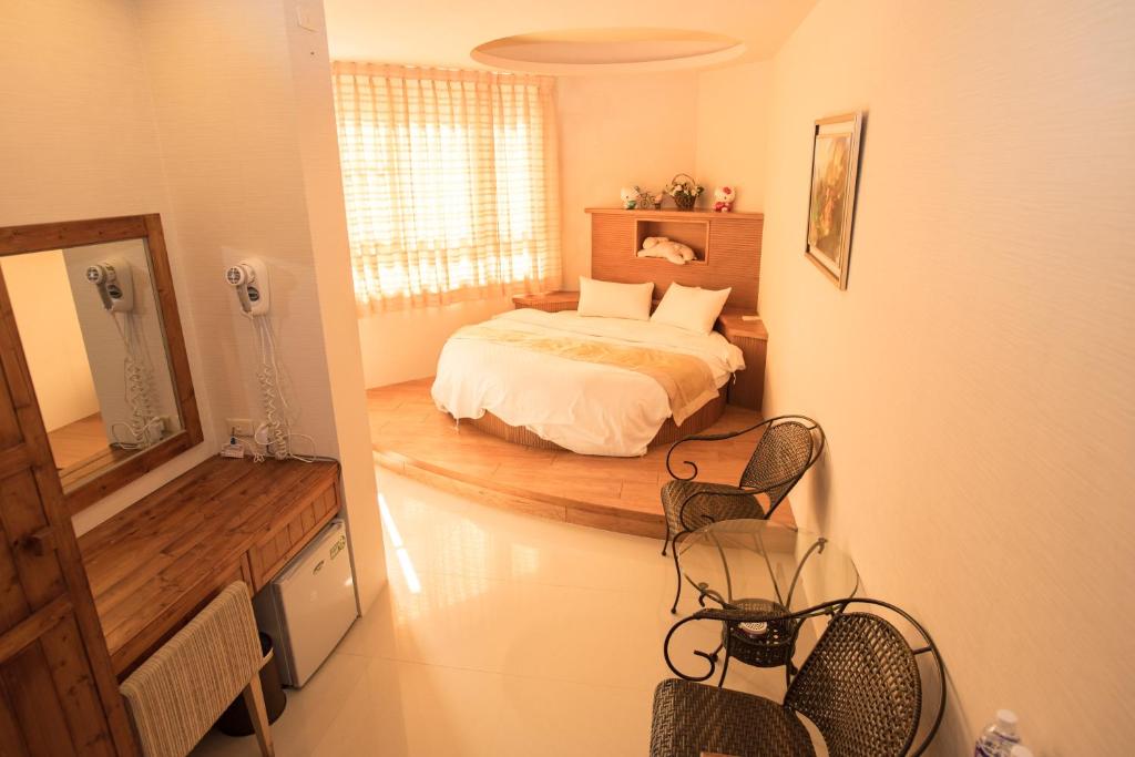 1 dormitorio con 1 cama, mesa y sillas en Long Hong, en Magong