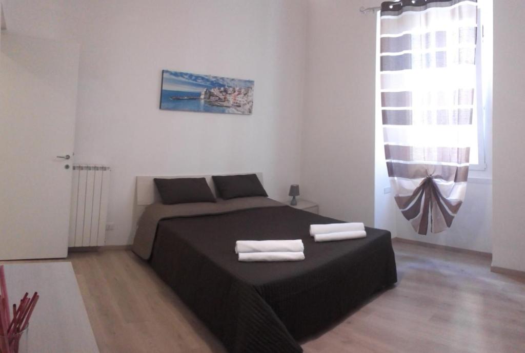 sypialnia z łóżkiem i dwoma ręcznikami na nim w obiekcie Alysia Apartment w Genui