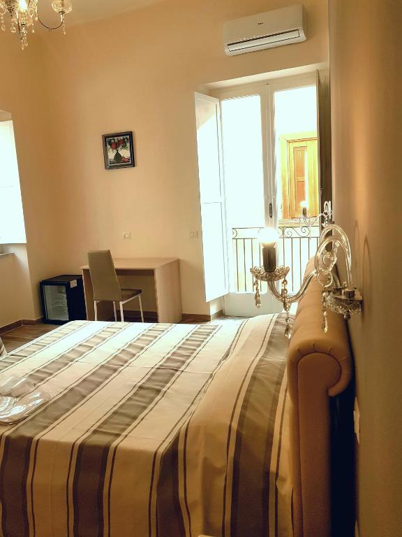 a bedroom with a bed with a striped blanket at B&B The Tower in Tropea