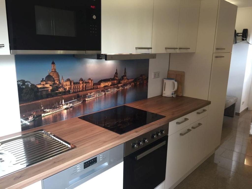 una cocina con una foto de una ciudad en la pared en Ferienwohnungen Rehn, en Dresden