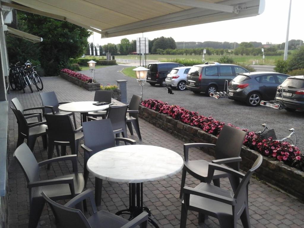 un grupo de mesas y sillas en un estacionamiento en Arconaty Hotel, en Linter