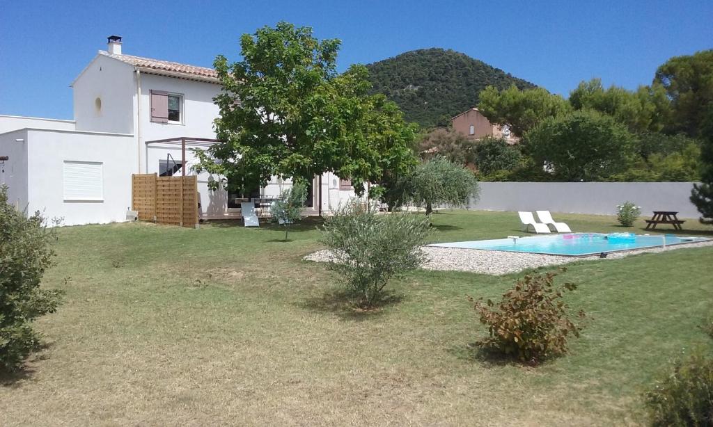 a white house with a swimming pool in a yard at La bastide de Lily in Séguret