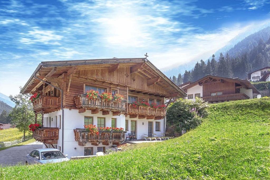 een huis met balkons en bloemen op een heuvel bij Lärchenheim in Neustift im Stubaital