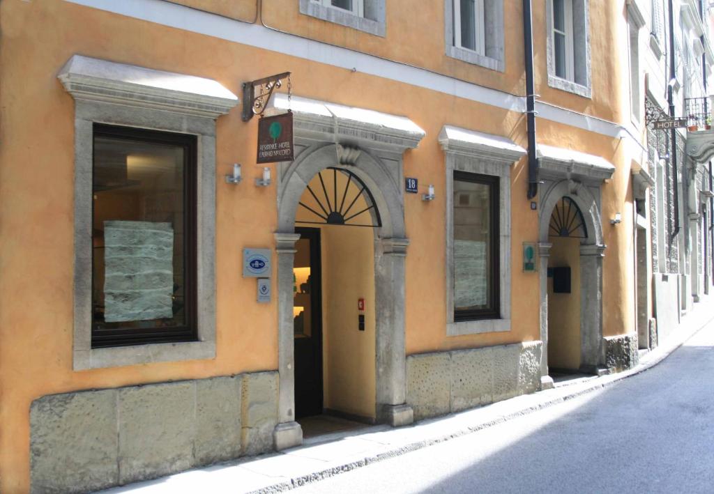 uma entrada para um edifício com uma arcada numa rua em Boutique Hotel Albero Nascosto em Trieste