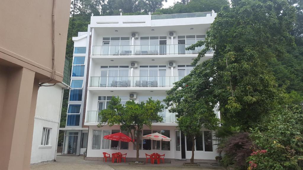 un edificio bianco con tavoli e ombrelloni di fronte di Hotel Del Mar a Kvariati