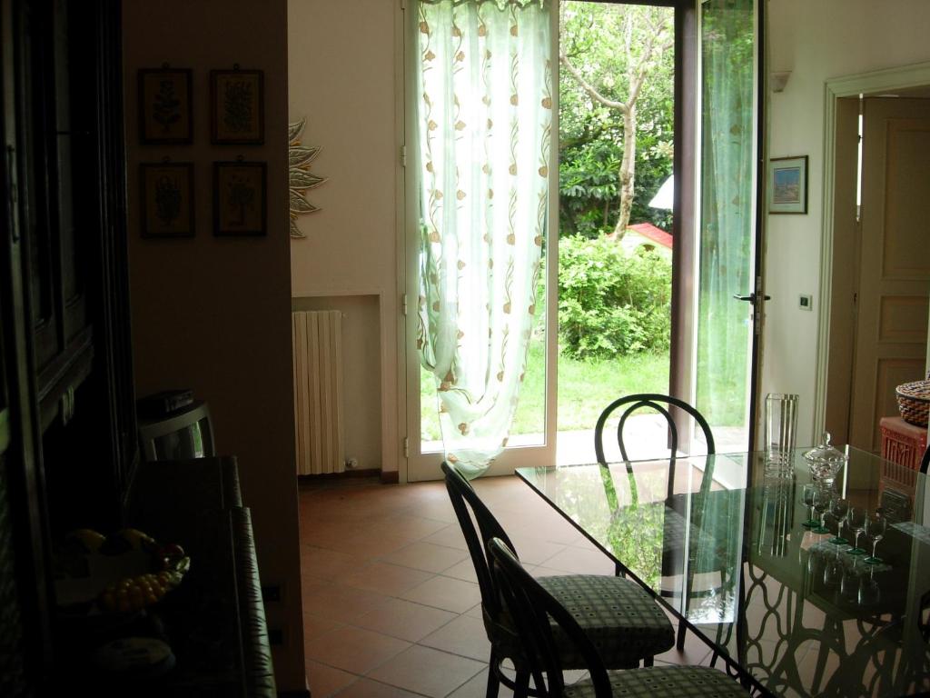 a dining room with a glass table and chairs at Appartamento Giardino Verde in Modena