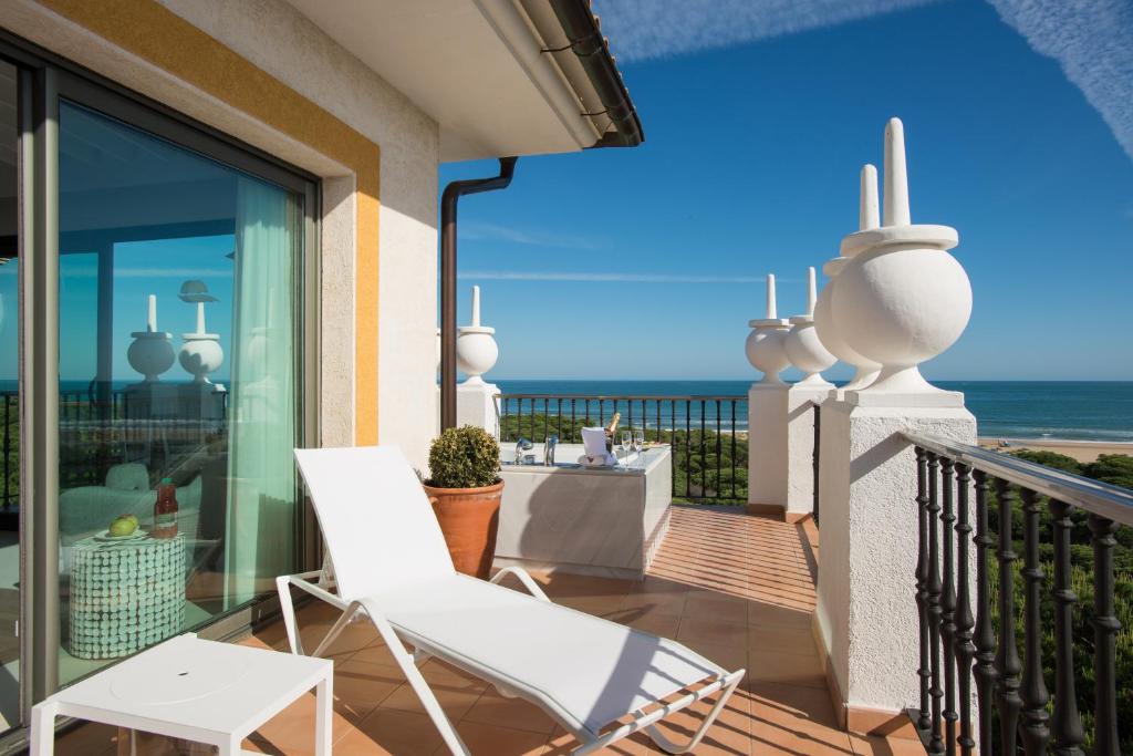 a balcony with a white chair and a view of the ocean at TUI Blue Isla Cristina Palace - Adults Recommended in Isla Cristina