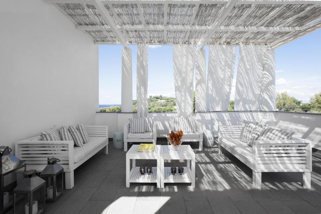 a living room with white furniture and a large window at La Suite Boutique Hotel in Procida