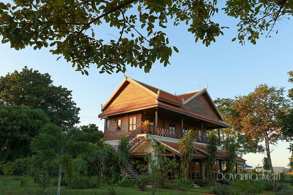 a large wooden house with a balcony on top at Green Plateau Lodge in Banlung
