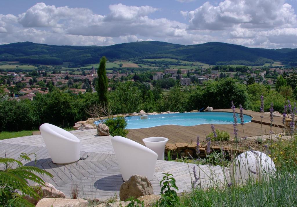 una piscina en un jardín con vistas a la ciudad en La Villa Montillet, en Cluny