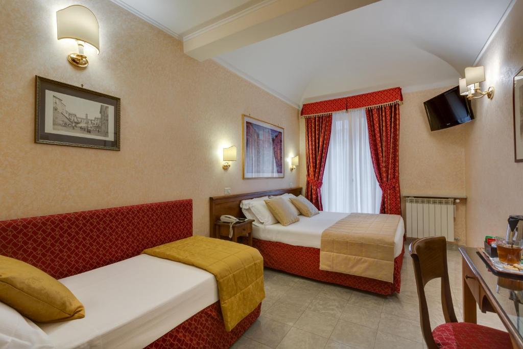 um quarto de hotel com duas camas e uma mesa em Hotel Silla em Roma