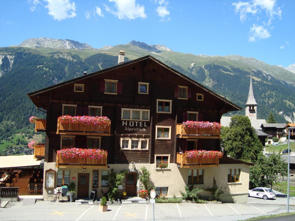 a hotel with flower boxes on the front of it at Hotel Restaurant Alpenblick in Ernen