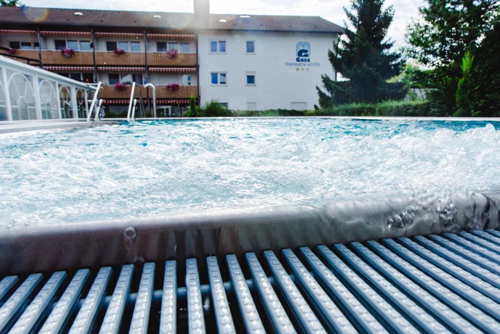 a pool of water with a bench in front of a building at Apartmenthaus Gass in Bad Füssing