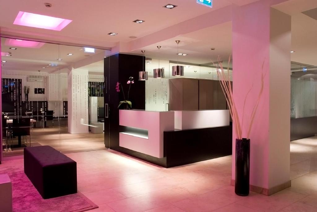 un vestíbulo con muebles de color rosa y negro y una mesa en Pearl Design Hotel - Frankfurt City, en Frankfurt