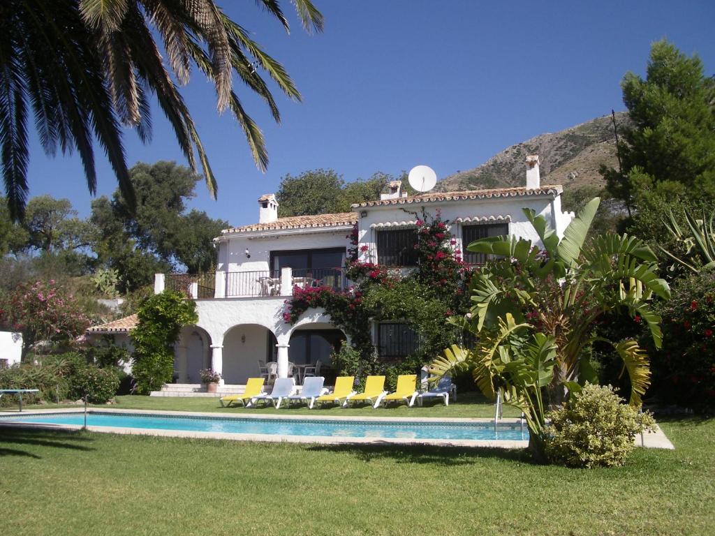 a house with a swimming pool in front of it at Villa El Capricho in Mijas