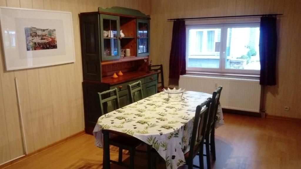 un comedor con una mesa con sillas y una ventana en Le Blanc Moussi en Stavelot