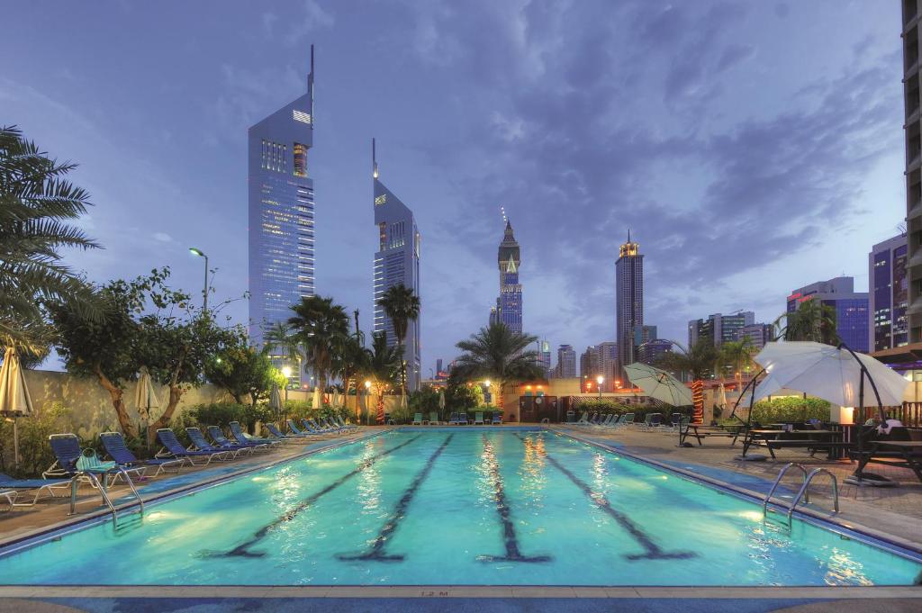 مركز دبي التجاري للشقق الفندقية في دبي: مسبح كبير في مدينة ذات مباني طويلة