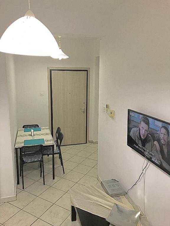 a living room with a table and a tv on the wall at Alex Flat in Neoi Epivates