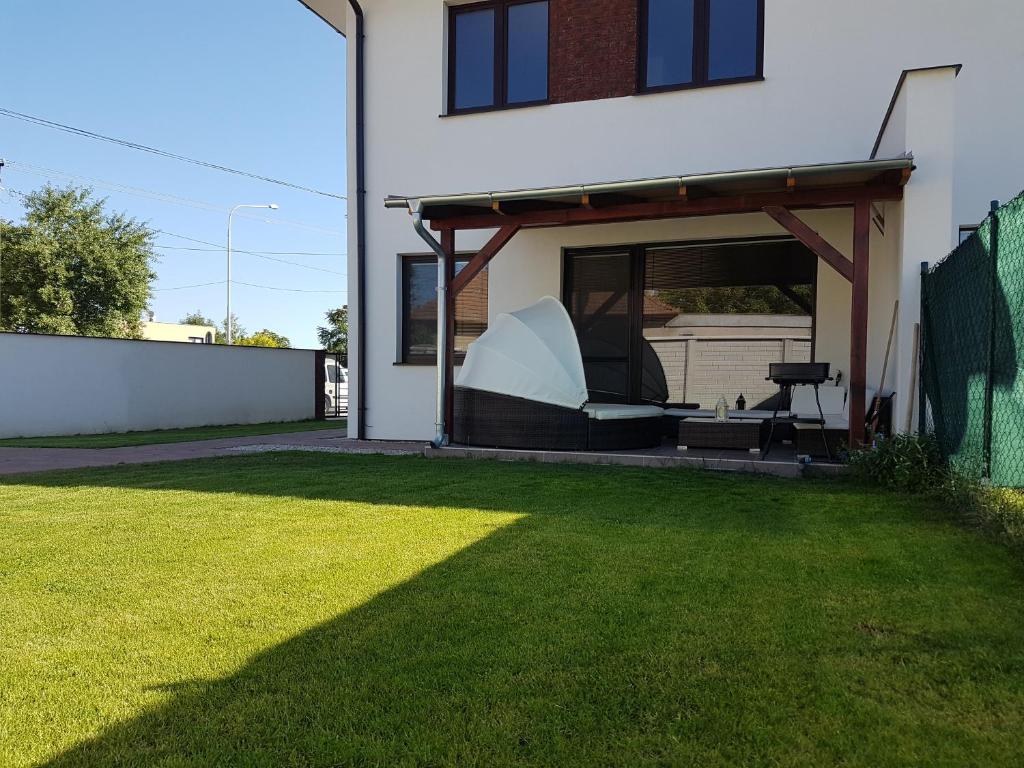 a backyard with a gazebo and a lawn at Apartment J&D in Dunajská Streda