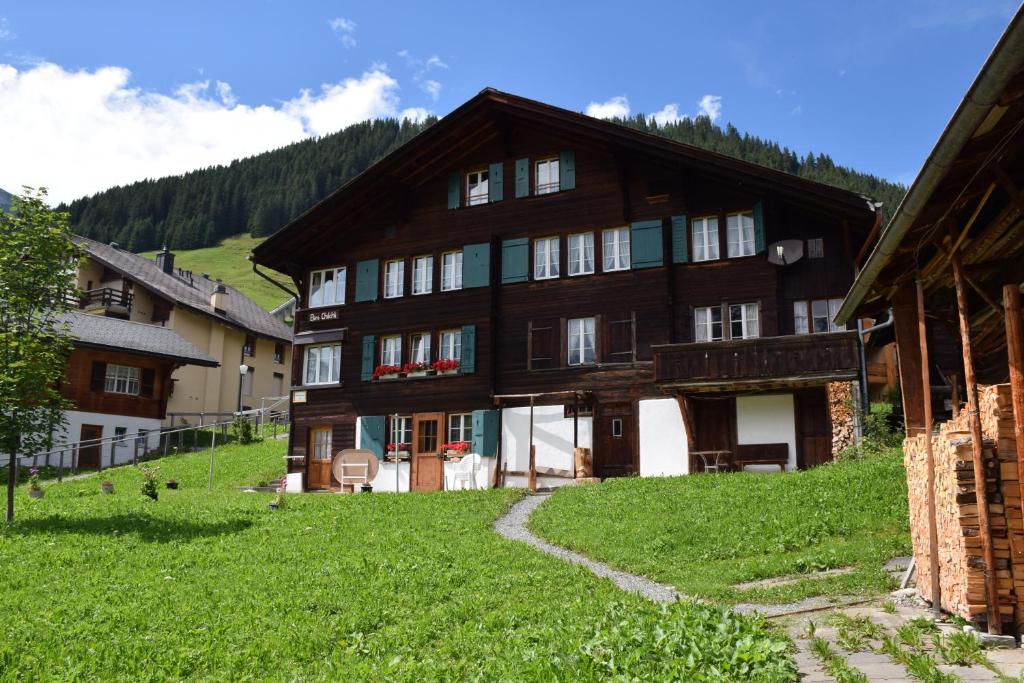 uma grande casa de madeira numa colina com relva verde em Chalet Bim Chilchli em Mürren
