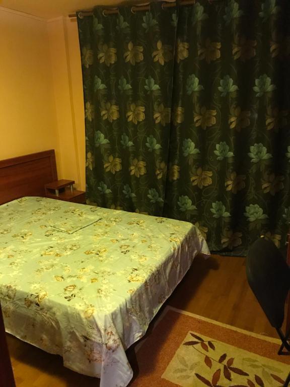 a bedroom with a bed and a curtain with flowers at casa lux central in Slatina