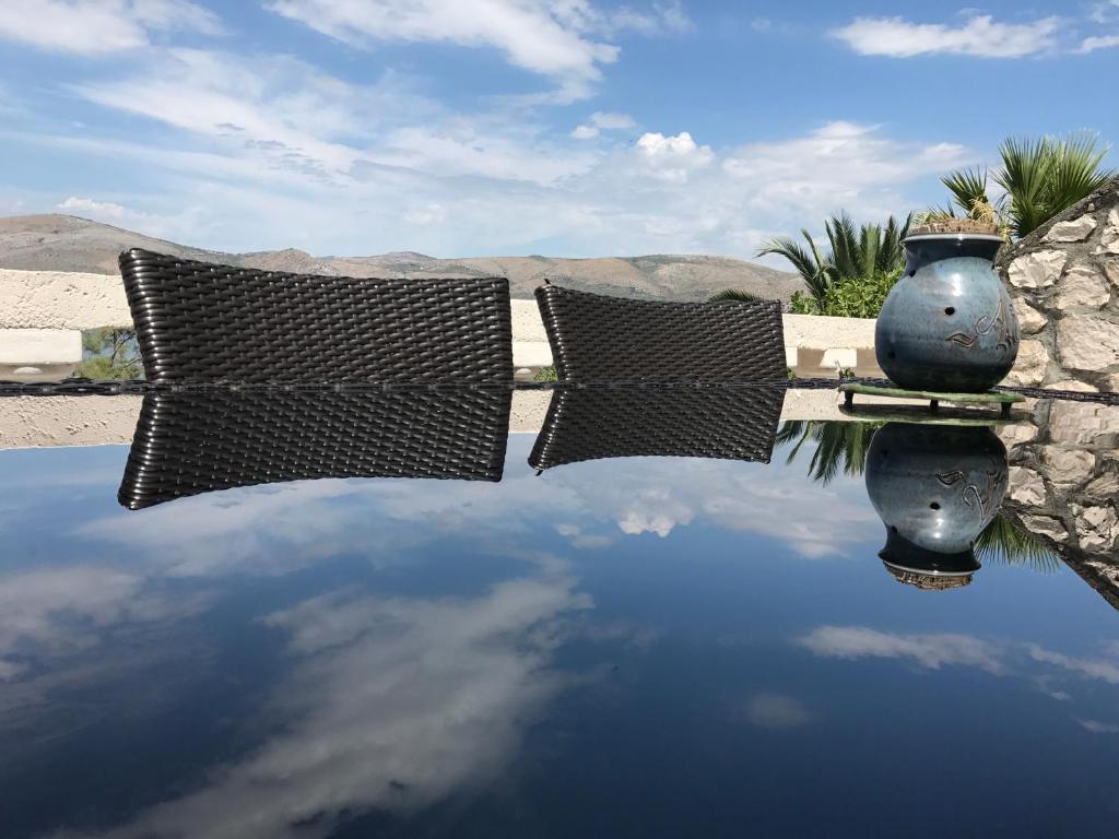een plas water met een reflectie van de lucht bij Apartments Villa Julia in Trogir