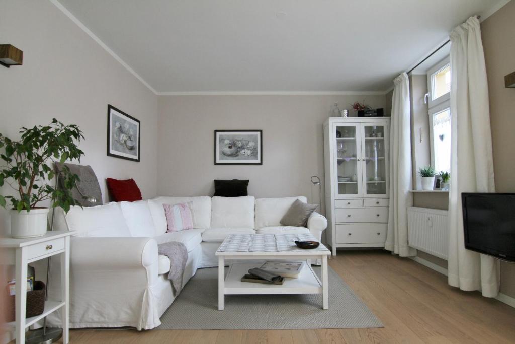 uma sala de estar com um sofá branco e uma televisão em FeWo Schweriner Altstadt em Schwerin