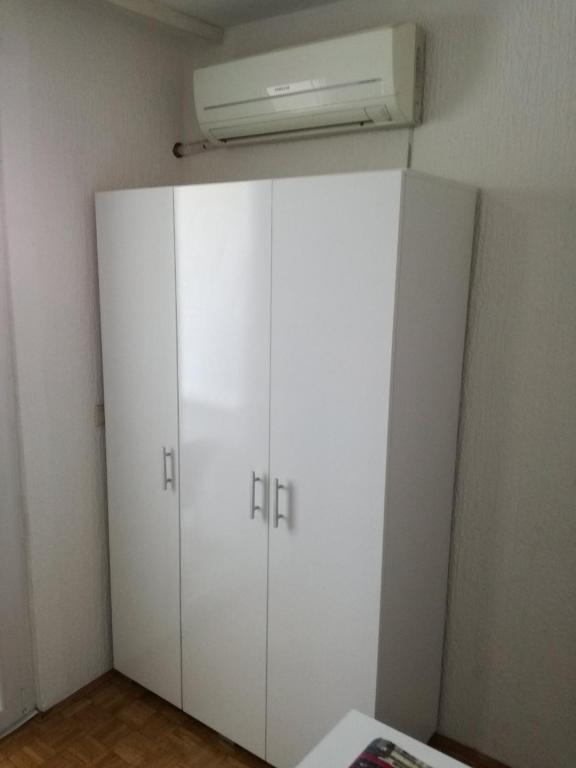 a white cabinet in a room with a fan at Apartment Pluvia in Osijek
