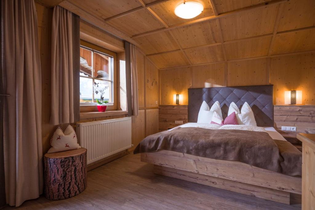 ein Schlafzimmer mit einem Bett in einem Holzzimmer in der Unterkunft Ferienhaus Waidmannsruh in Hippach