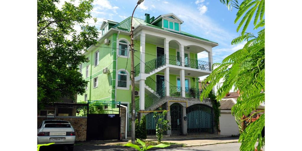 a green and white house with a balcony at Private house on Trudyashchikhsya in Anapa