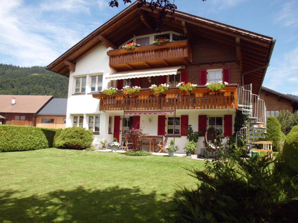 a house with a balcony with flowers on it at Ferienwohnung Annele in Hittisau