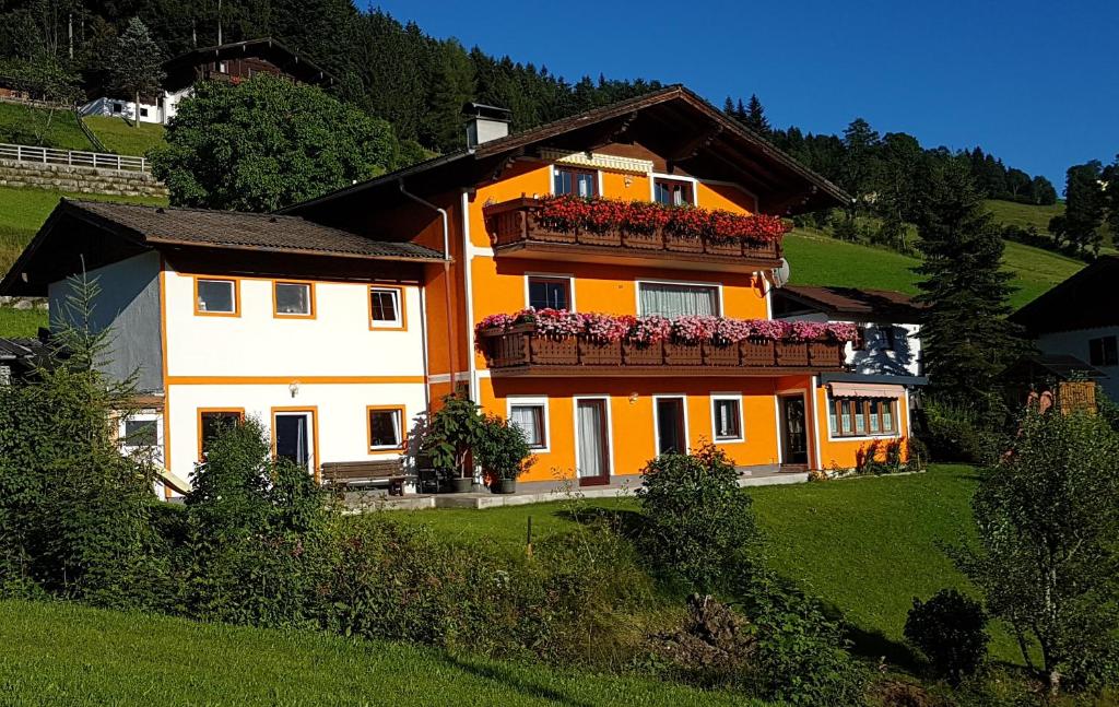 an orange and white house with flower boxes on it at Göllblick in Sankt Koloman