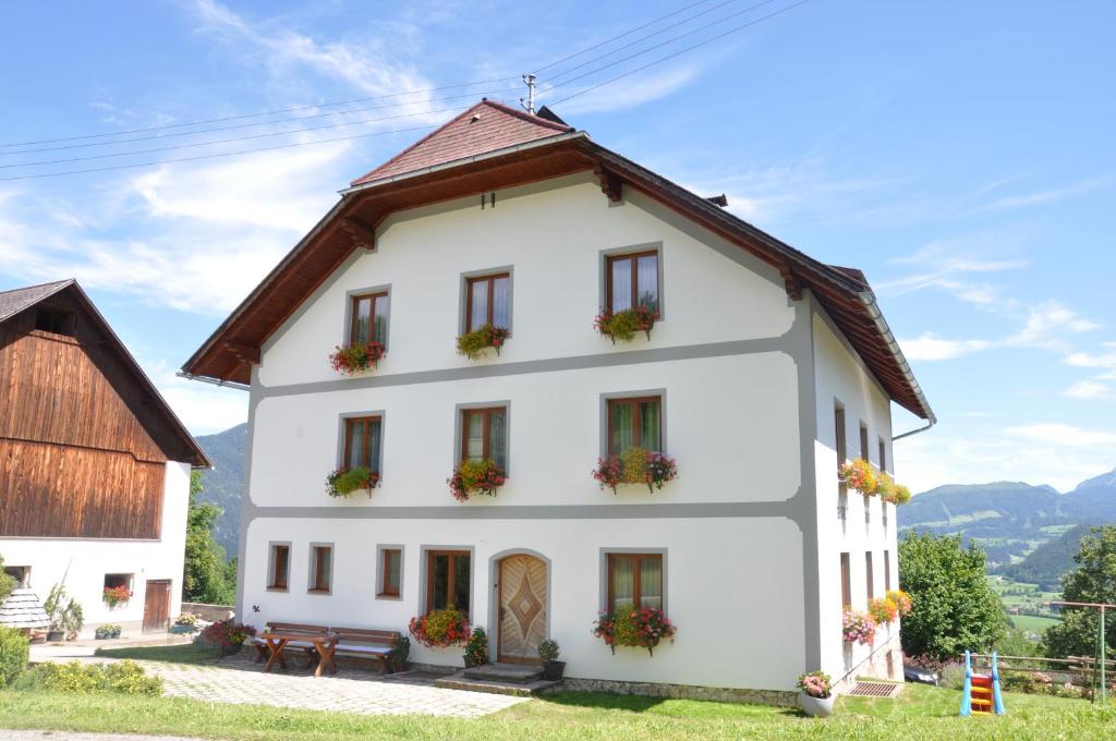 una casa blanca con flores en las ventanas en Ferienhof Berger, en Rossleithen