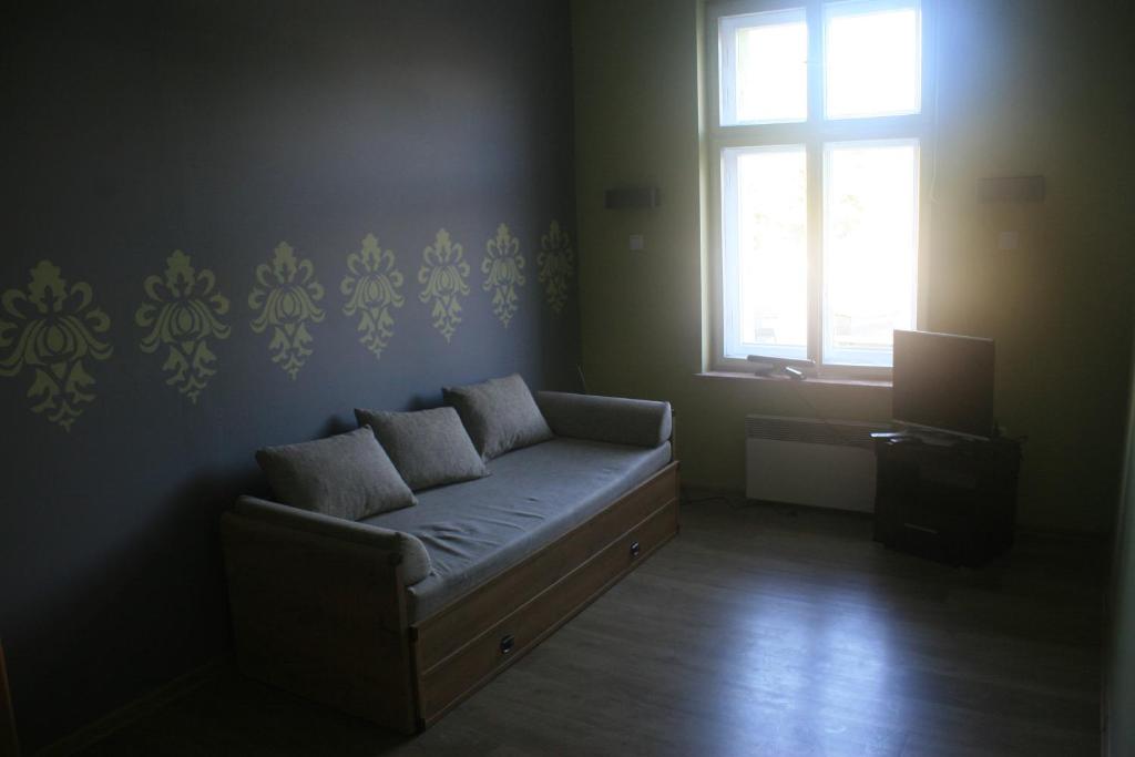 un soggiorno con divano e finestra di Mieszkanie centrum 300m od plaży a Giżycko