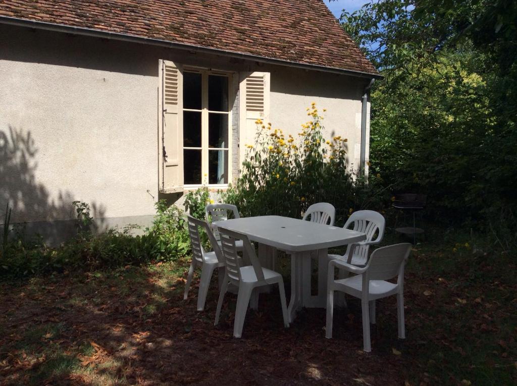 a table and chairs in front of a white house at Les vaulx in Cour-Cheverny
