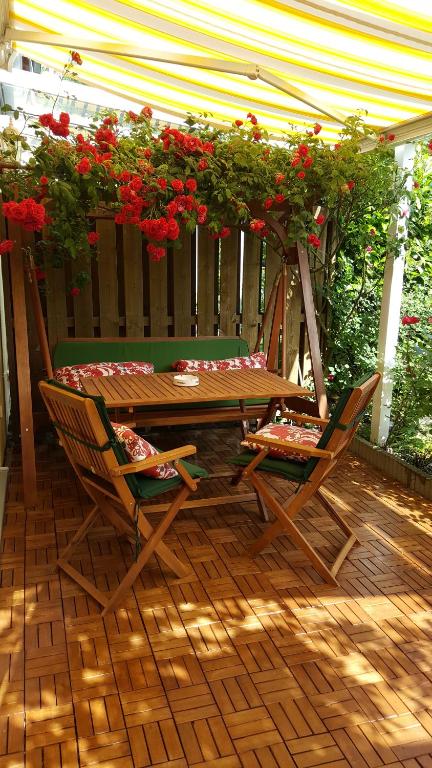 ハノーファーにあるExklusives Haus mit Gartenの赤い花が咲くパティオ(木製テーブル、椅子付)