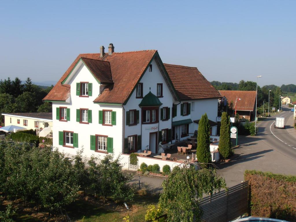 ein großes weißes Haus mit braunem Dach in der Unterkunft Don Camillo Gästehaus in Hörhausen