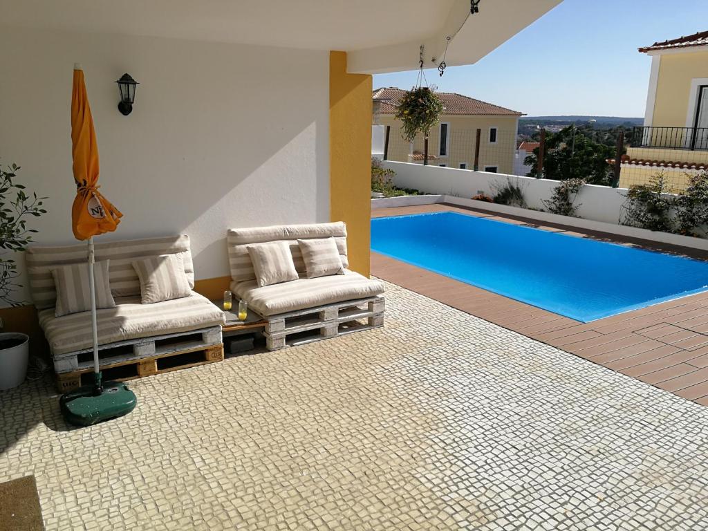 a patio with two chairs and a swimming pool at Alentejo`s Nest in Alcácer do Sal