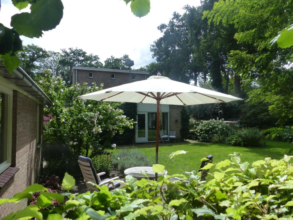 a table with an umbrella in a yard at B&B Cantecleer Vught in Vught