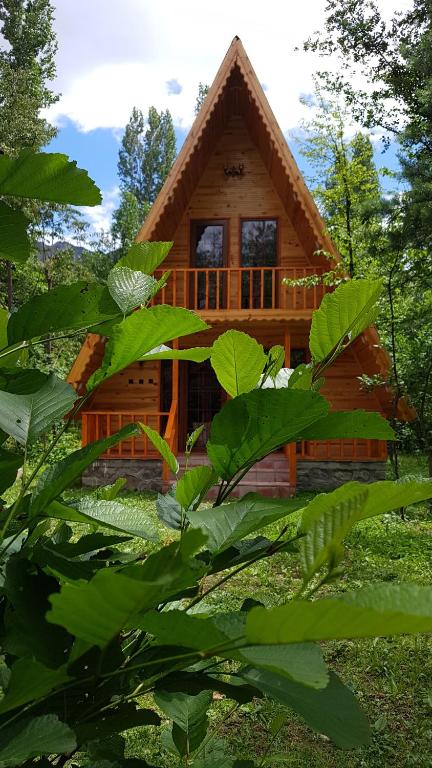 a log cabin in the woods with green leaves at Eliya Otel Restoran in Akarsu