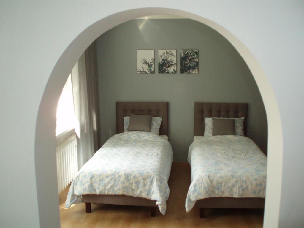 two beds in a room with an archway at Budget Stay in Szczecin