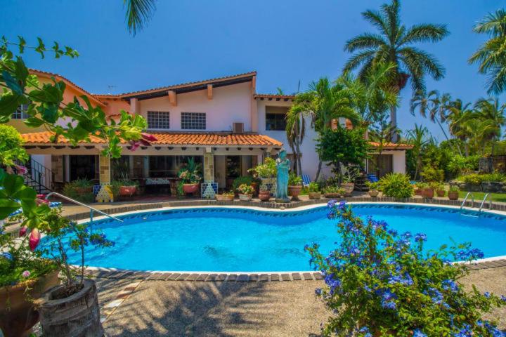 a large swimming pool in front of a house at Casa Virgilios B&B in Nuevo Vallarta