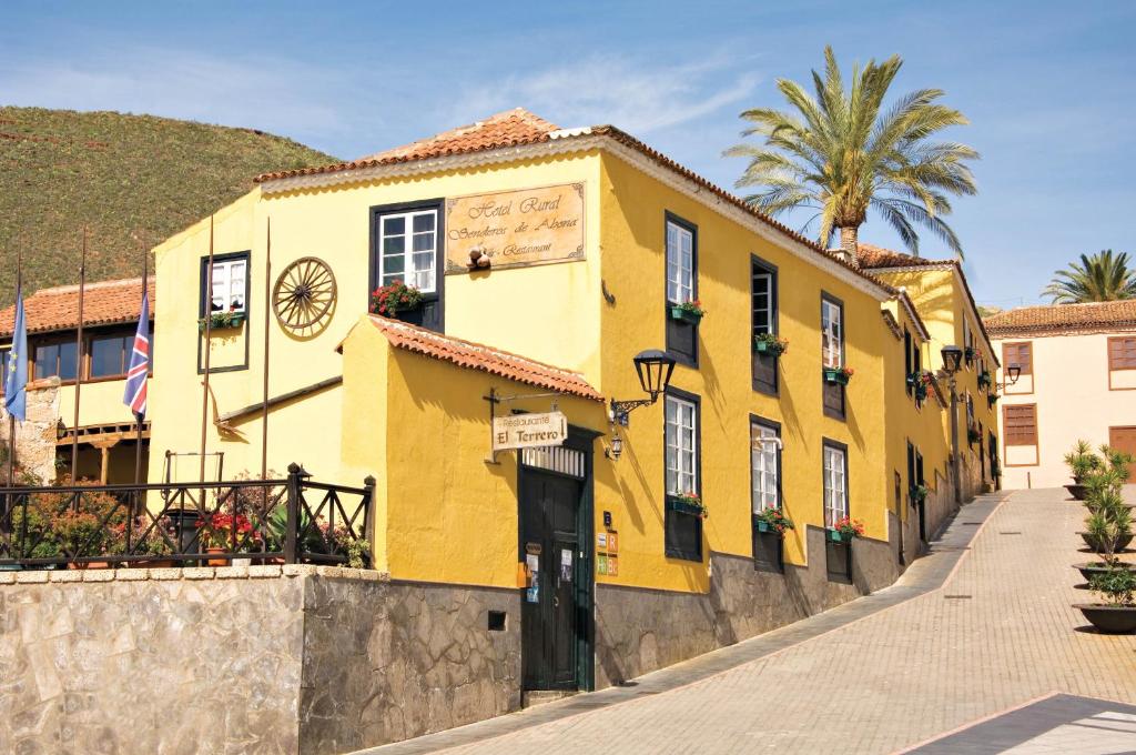 um edifício amarelo no lado de uma rua em Hotel Rural Senderos de Abona em Granadilla de Abona