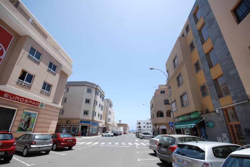 Una calle de la ciudad con coches aparcados en la calle. en Beach Holiday Home Fue, en Gran Tarajal