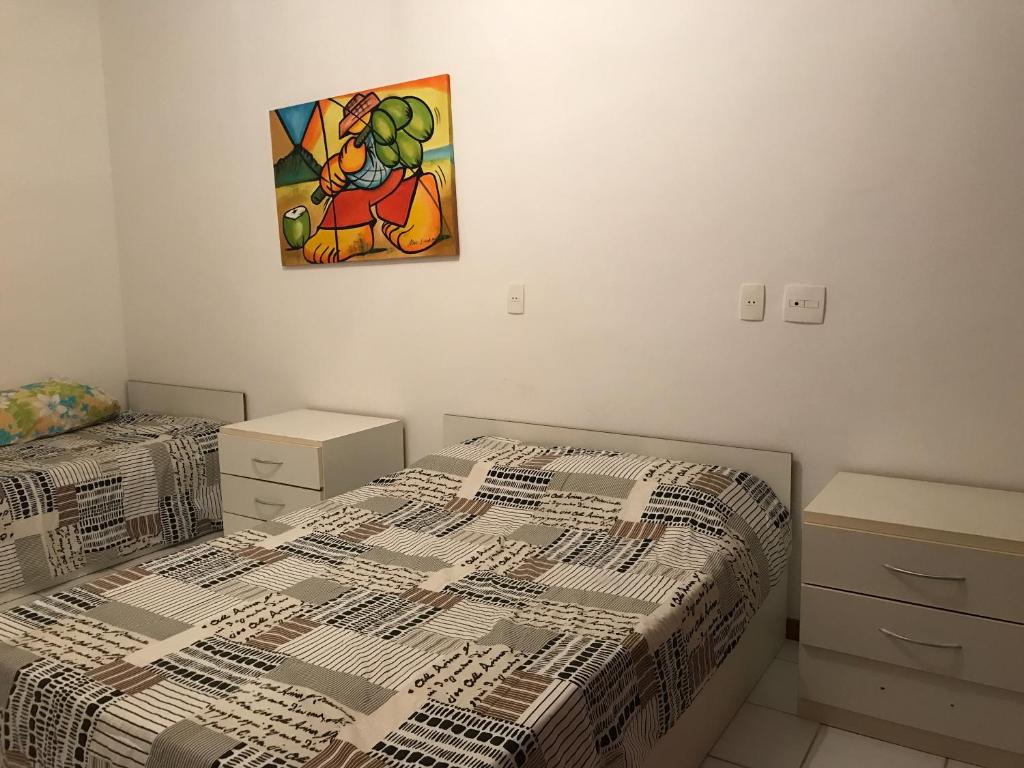 een slaapkamer met 2 bedden en een schilderij aan de muur bij Vilage em Praia do Forte in Praia do Forte