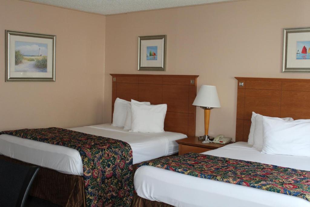une chambre d'hôtel avec deux lits et une lampe dans l'établissement Capri Motel, à North Dartmouth