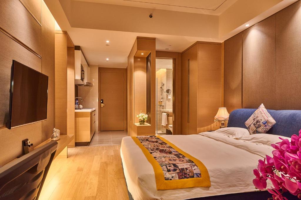 a bedroom with a large bed and a flat screen tv at Heefun International Apartment - Zhujiang New Town FuLi Brand New World Plaza in Guangzhou